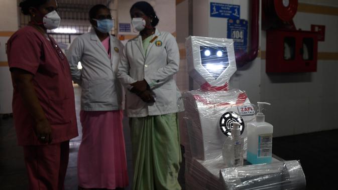 Staf medis berpartisipasi dalam demo robot interaktif 'Zafi' di rumah sakit Stanley Medical di Chennai, 6 April 2020. Rumah sakit ini mengerahkan robot untuk melayani makanan dan obat-obatan bagi pasien Covid-19 dalam upaya meminimalkan tenaga medis tertular virus corona. (Arun SANKAR/AFP)