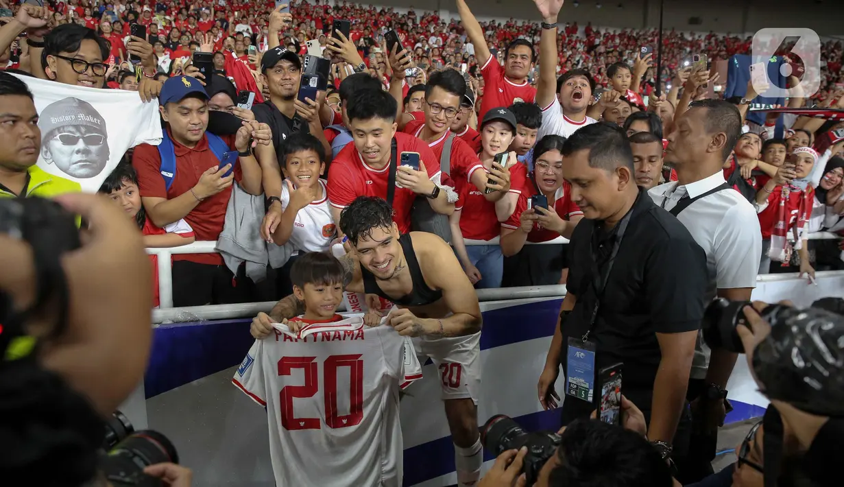 Pemain timnas Indonesia, Shayne Pattynama menyempatkan berfoto dan memberikan kaosnya kepada salah satu pendukung cilik skuad Garuda. (Liputan6.com/Herman Zakharia)