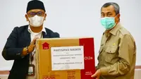 Ketua DPP Apkasindo menyerahkan bantuan masker dari petani sawit ke Gubernur Riau Syamsuar. (Liputan6.com/Istimewa)