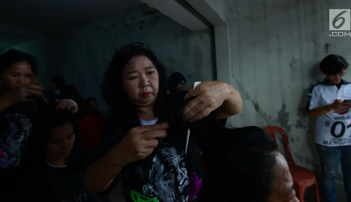Warga RW 1 Koja, Jakarta Utara, menikmati potong rambut gratis, Jakarta, Sabtu (1/12). Kegiatan tersebut diselenggarakan Sahabat Indonesia Maju (SIMA) dan sebagai bentuk bakti sosial kepada masyarakat. (Merdeka.com/Imam Buhori)