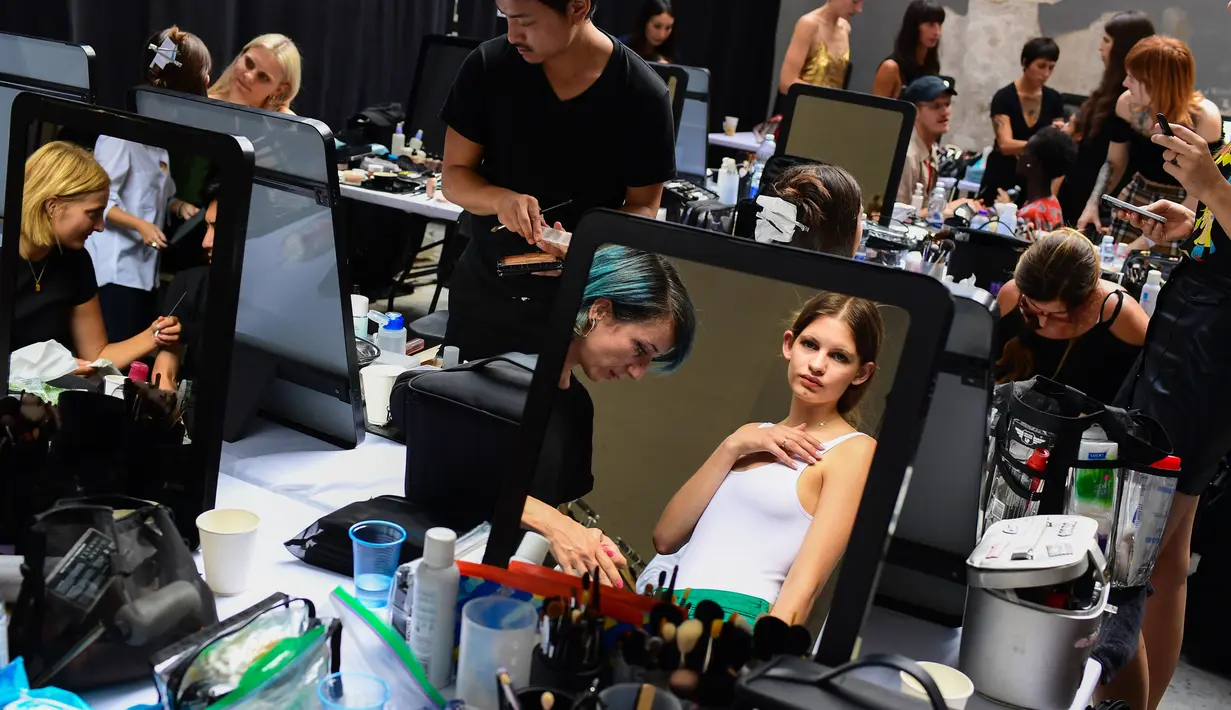 Seorang model  berkaca  di belakang panggung sebelum tampil mengenakan busana Women Spring/Summer 2019 karya Jil Sander selama Milan Fashion Week di Italia (19/9). (AFP Photo/Miguel Medina)
