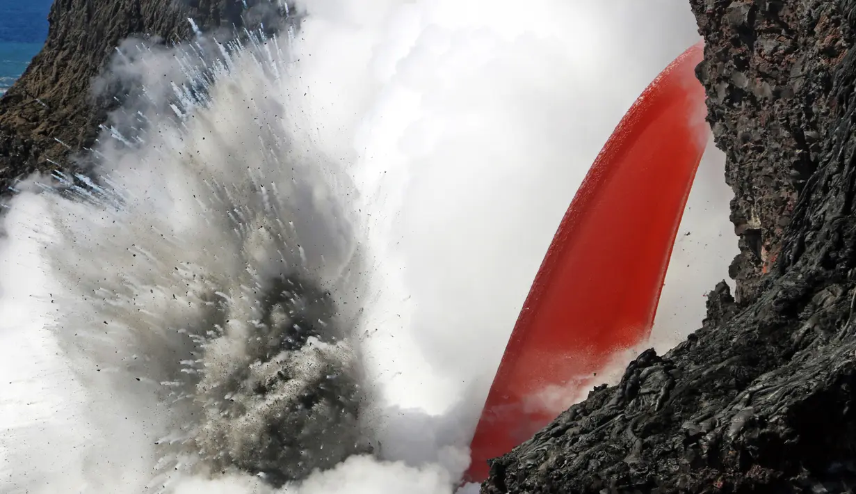 Reaksi ledakan saat lava meluncur ke air laut di Samudra Pasifik, Hawaii, Rabu (1/2). Fenomena mengalirnya lava bak air terjun ini menjadi daya tarik wisatawan. (Shane Turpin / Lava Ocean Tours via AP)