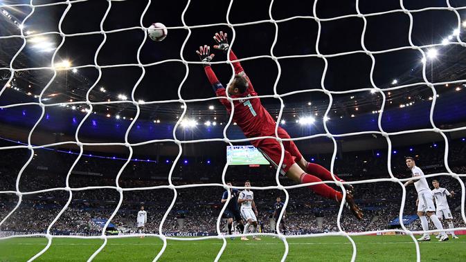 Penjaga gawang Jerman, Manuel Neuer gagal menepis penalti Antoine Griezmann saat menghadapi Prancis pda UEFA Nations League di Stadion Stade de France, Paris, Selasa (16/10). Dua gol Griezmann membawa Prancis menaklukkan Jerman 2-1. (FRANCK FIFE/AFP)