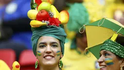 Menggunakan hiasan replika buah-buahan, salah satu suporter tim Samba menyaksikan langsung laga Brasil kontra Kamerun di Stadion Nasional Brasil, (23/6/2014). (REUTERS/Dominic Ebenbichler)