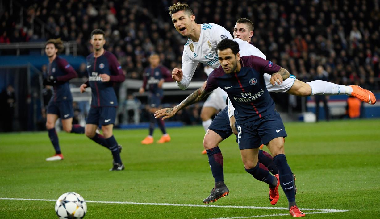 Bintang Real Madrid, Cristiano Ronaldo berebut bola dengan bek PSG, Dani Alves pada laga Liga Champions di Stadion Parc des Princes, Paris, Selasa (6/3/2018). PSG kalah agregat 2-5 dari Madrid. (AFP/Christophe Simon)
