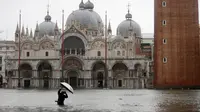 Fotografer mengambil gambar Alun-Alun Santo Markus yang banjir akibat gelombang pasang di Venesia, Italia, Selasa (12/11/2019). Venesia dilanda banjir akibat gelombang pasang setinggi 127 cm. (AP Photo/Luca Bruno)