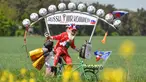 Perancang sepeda asal Jerman, Dieter Senft atau Didi the Devil saat mengendarai sepeda unik buatannya di Briesen, Jerman Timur, Senin (7/5). Aksi itu dia lakukan untuk mempromosikan Piala Dunia 2018. (Patrick Pleu/dpa/AFP)