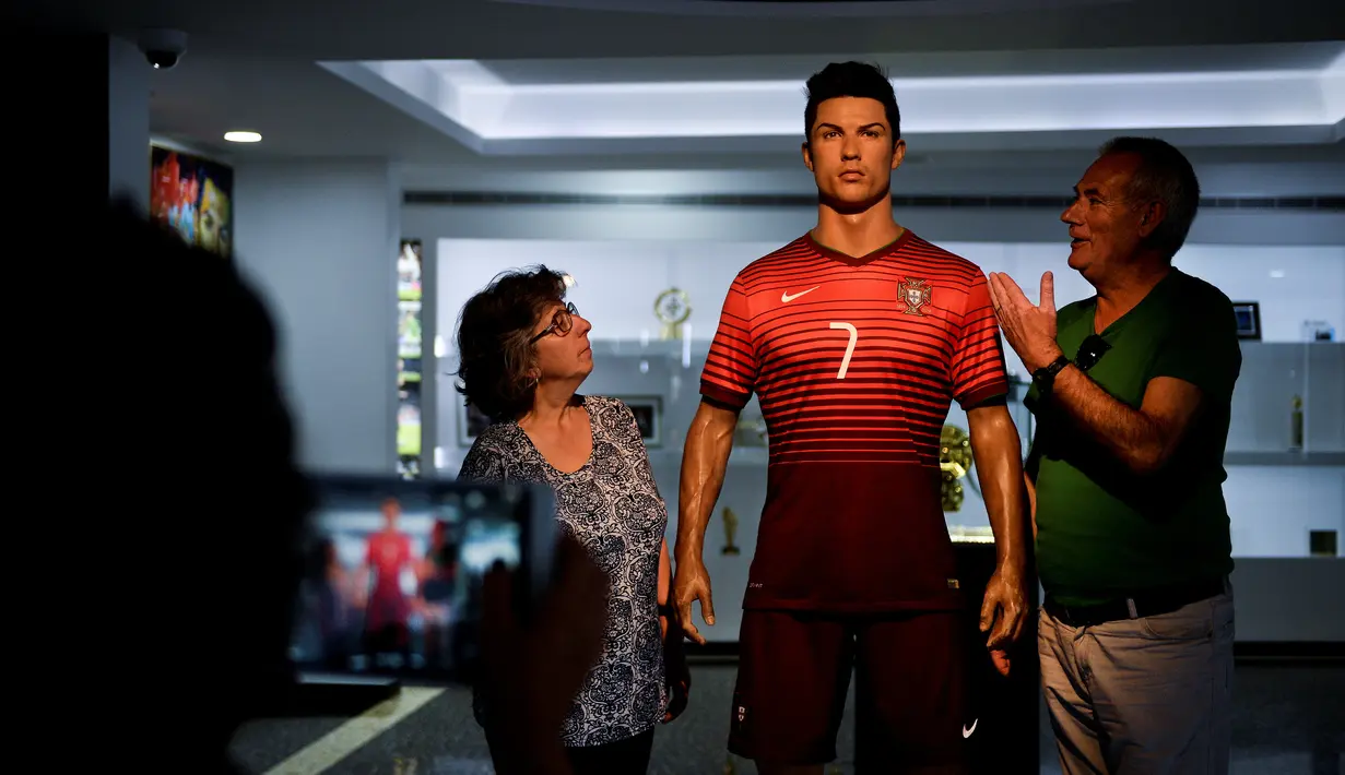 Pengunjung berfoto dengan patung Cristiano Ronaldo di Museum CR7 yang terletak di kampung halamannya di Funchal, Madeira, Portugal, (29/4/2016). (AFP/Patricia De Melo Moreira)