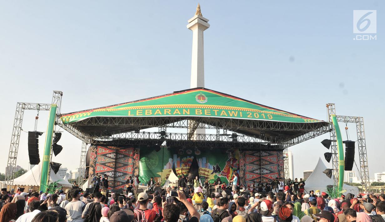 Warga menyaksikan salah satu pertunjukkan kesenian Betawi saat Lebaran Betawi di Monas, Jakarta, Minggu (21/7/2019).Untuk pertama kalinya Lebaran Betawi digelar di Monas yang diisi oleh beragam seni dan budaya masyarakat Betawi dalam rangka memeriahkan HUT DKI Jakarta. (merdeka.com/Iqbal S. Nugroho)