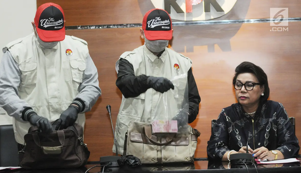 Wakil Ketua KPK Basaria Panjaitan (kanan) mendampingi petugas KPK menunjukkan uang hasil OTT Kabupaten Bengkayang di Gedung KPK, Jakarta, Rabu (4/9/2019). Bupati Bengkayang Suryadman Gidot diduga menerima suap dari swasta terkait pengerjaan proyek di kabupaten tersebut. (Merdeka.com/Dwi Narwoko)