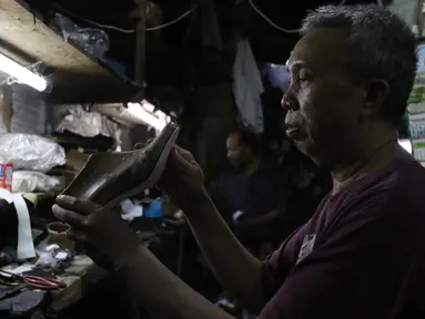 Seorang perajin menyelesaikan pembuatan sepatu di Jakarta, Jumat (17/1/2020). Pengamat menilai perlambatan pertumbuhan kredit usaha mikro, kecil, dan menengah (UMKM) berpotensi tidak akan berlanjut pada tahun ini. (Liputan6.com/Angga Yuniar)