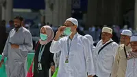 Umat Muslim mengenakan masker di Masjidil Haram, kota suci Makkah, Kamis (27/2/2020). Suasana Masjidil Haram berjalan sebagaimana biasanya pascapengumuman Pemerintah Arab Saudi melarang sementara jemaah umrah ke Tanah Suci terkait pencegahan penyebaran virus korona. (Abdulghani BASHEER/AFP)