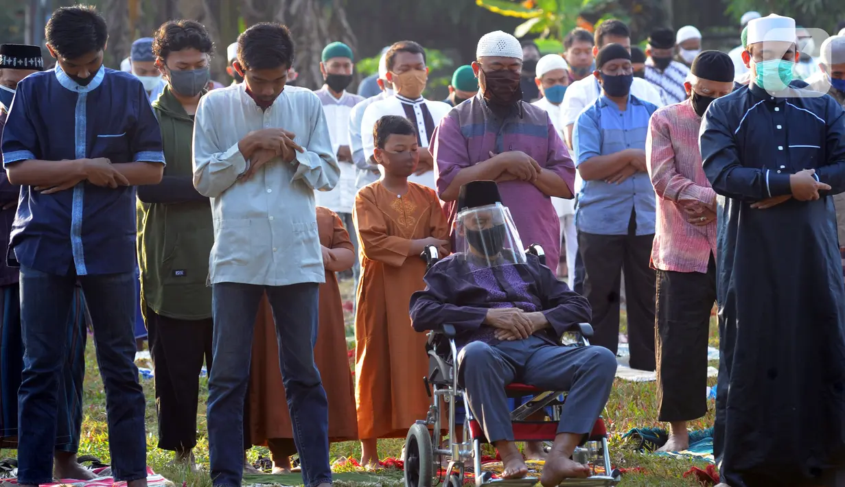 Warga mengenakan masker saat melaksanakan salat Idul Adha di Lapangan Perumahan Sawangan Permai, Depok, Jawa Barat, Jumat (31/7/2020). Hari ini, seluruh umat muslim di dunia merayakan Idul Adha 1441 H yang dilanjutkan dengan pemotongan hewan kurban. (merdeka.com/Arie Basuki)