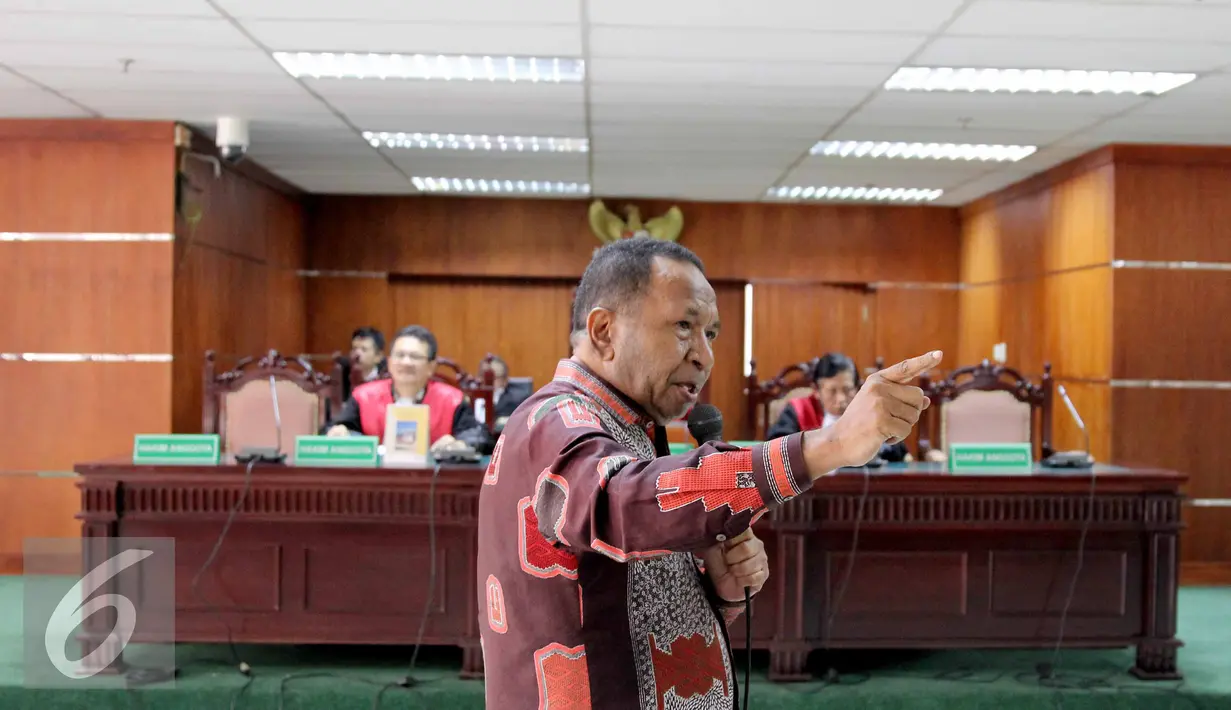 Jannes Johan Karubaba menyanyikan lagu Indonesia Raya usai dibacakan dakwaan saat sidang perdana korupsi pengadaan "Detailing Engineering Design" di Sungai Mamberamo dan Urumka, Gedung Tipikor, Jakarta, Senin (13/7/2015). (Liputan6.com/Helmi Afandi)