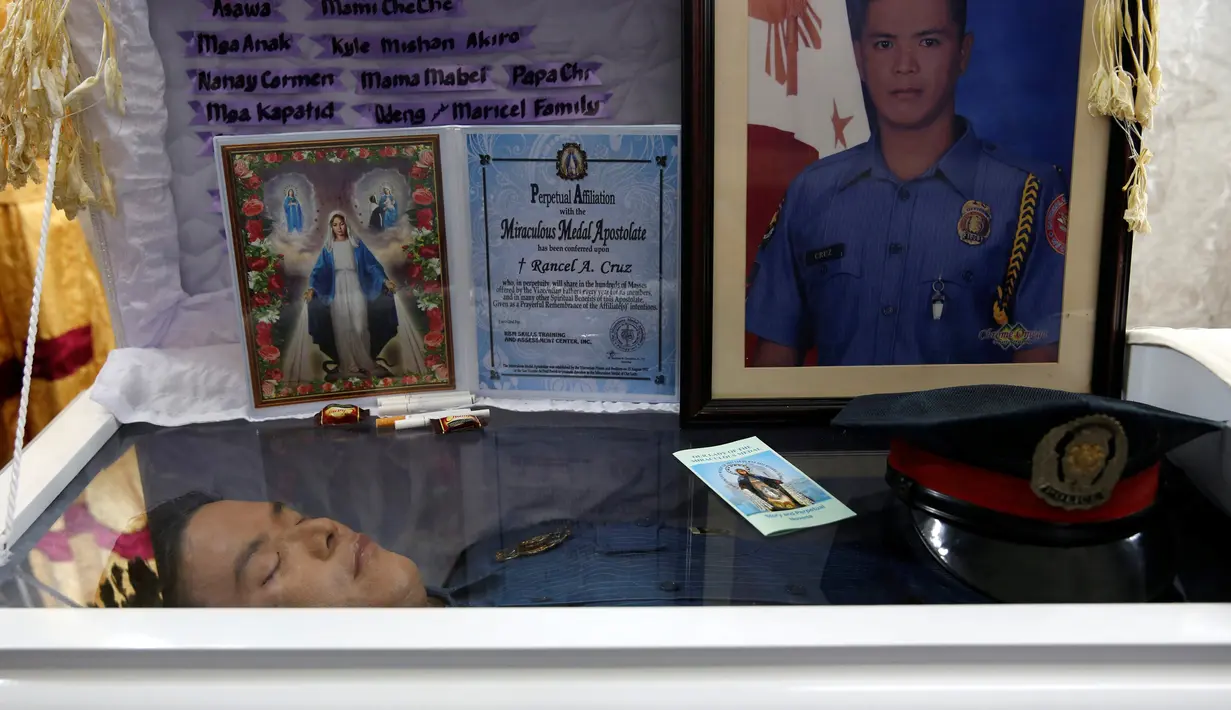  Jasad petugas kepolisian Filipina, Rancel Cruz terbaring di atas peti mati usai ditembak pecandu narkoba di Manila, Filipina, (19/10). Langkah tegas pemerintah Filipina membuat para pengguna narkoba membalas menembak petugas. (REUTERS/Erik De Castro)