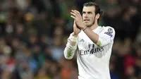 Gelandang Real Madrid, Gareth Bale, menyapa suporter saat tampil melawan Wolfsburg pada laga Liga Champions di Stadion Santiago Bernabeu, Spanyol, Selasa (12/4/2016). (AFP/Javier Soriano)
