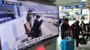 Warga melewati layar TV yang menyiarkan berita tentang pemimpin Korut, Kim Jong-Un di stasiun kereta di Seoul, Korsel, Jumat (4/3). Kim Jong-Un memerintahkan pasukannya menyiagakan senjata nuklir untuk bisa digunakan kapan saja. (AFP PHOTO/Jung YEON-JE)