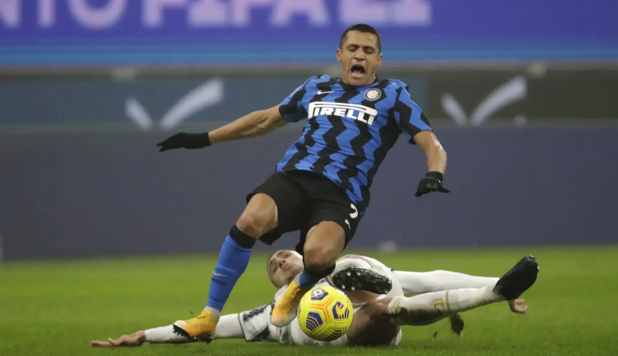 Bek Juventus, Merih Demiral (bawah) menghentikan penyerang Inter Milan, Alexis Sanchez pada laga leg pertama semifinal Coppa Italia di San Siro, Rabu (3/2/2021) dini hari WIB.  Juventus membuka peluang untuk lolos final Coppa Italia usai kalahkan Inter Milan 2-1. (AP Photo/Luca Bruno)