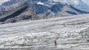 Seorang perserta lari melintas di Glacier Tsanfleuron saat mengikuti Glacier 3000 Run and Marathon di Les Diablerets, Swiss (5/8). Acara lomba lari yang melintasi pegungunan salju ini diikuti 1.200 peserta. (AFP Photo/ Fabrice Coffrini)