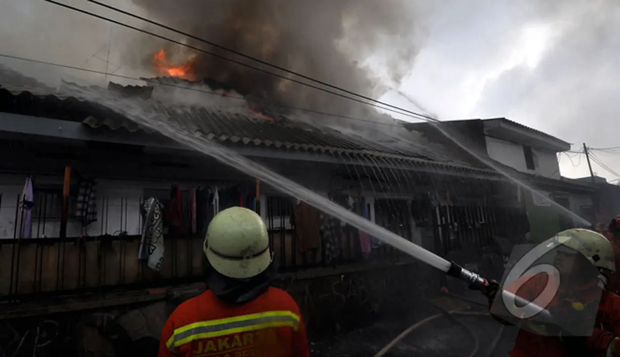 Api berkobar di atas rumah penduduk di kawasan Pasar Kembangan, Senen. Tampak petugas sedang berusaha memadamkan api, Jakarta, Senin(19/1/2015).  (Liputan6.com/Miftahul Hayat)
