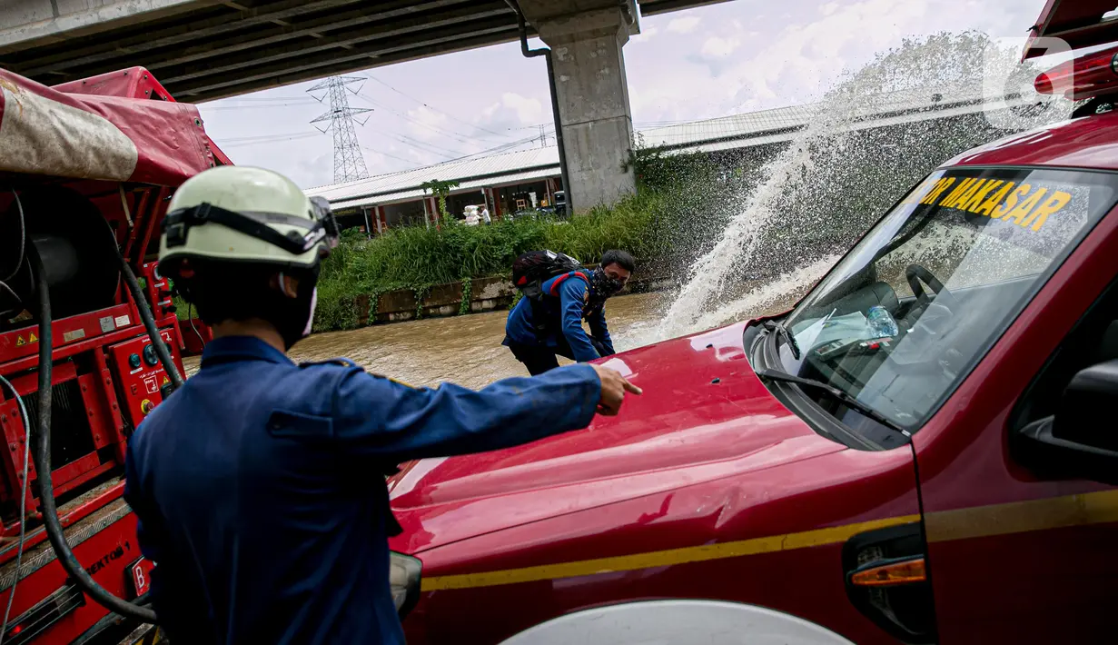 Petugas pemadan kebakaran menyedot air banjir di kawasan Cipinang Melayu, Jakarta, Minggu (21/2/2021). Suku Dinas Pemadam Kebakaran Jakarta Timur mengerahkan 20 mobil pompa untuk menyedot air yang membanjiri RW 04 Kelurahan Cipinang Melayu untuk mengurangi debit air. (Liputan6.com/Faizal Fanani)