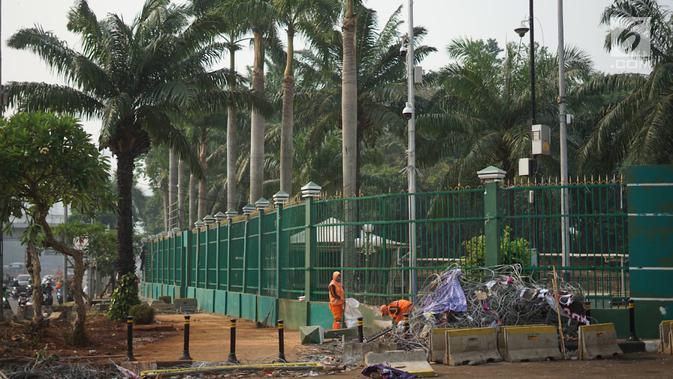 Petugas membersihkan sampah sisa bentrok antara mahasiswa dan polisi dalam unjuk rasa di depan Gedung DPR RI, Jakarta, Rabu (25/9/2019). Bentrokan pada Selasa (24/9/2019) menyisakan sampah yang memenuhi kawasan di sekitar Gedung DPR. (Liputan6.com/Immanuel Antonius)
