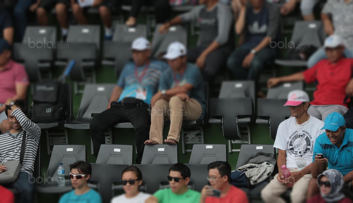 Diharapkan penyelenggara aktif mengingatkan penonton untuk tidak mengangkat kaki pada sandaran kursi di lapangan Tenis di Senayan, Jakarta, Sabtu (4/2/2018). Renovasi Lapangan Tenis ini memakan biaya sekitar 92 miliar rupiah.  (Bola.com/Nick Hanoatubun)