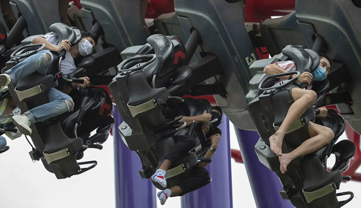 Pengunjung mengenakan masker saat menaiki rollercoaster Vortex di Siam Amazing Park, Bangkok, Thailand, Rabu (17/6/2020). Keseharian warga Bangkok berangsur normal setelah pemerintah terus melonggarkan pembatasan terkait pandemi virus corona COVID-19. (AP Photo/Sakchai Lalit)
