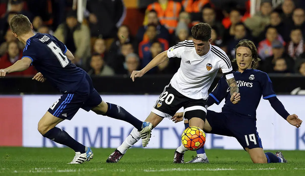 Gelandang Valencia, Rodrigo De Paul, berusaha melewati pemain Real Madrid, Luka Modric, pada laga La Liga Spanyol. Akibat hasil itu Madrid tertahan di posisi tiga klasemen sementara. (EPA/Juan Carlos Cardenas)
