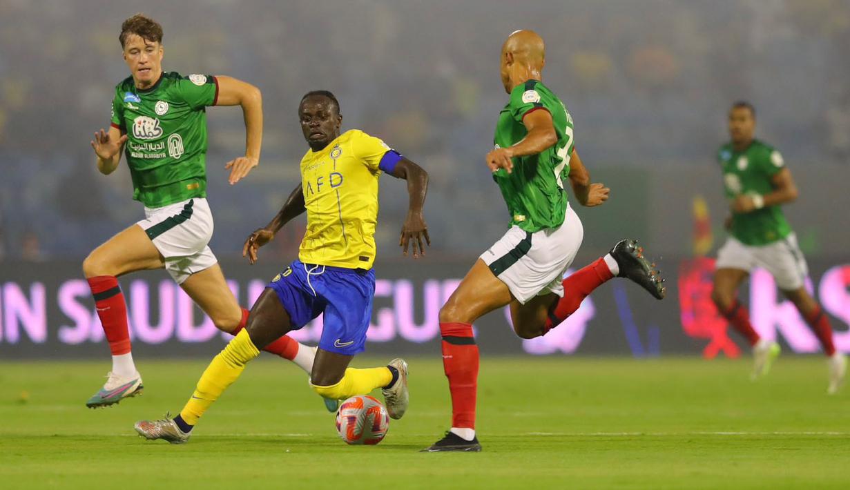 Pemain Al-Nassr, Sadio Mane (tengah) berusaha melewati pemain Al-Ettifaq pada laga pekan pertama Liga Arab Saudi 2023/2024 di Prince Mohamed bin Fahd Stadium, Dammam, Selasa (15/08/2023) dini hari WIB. (Twitter/@AlNassrFC_EN)