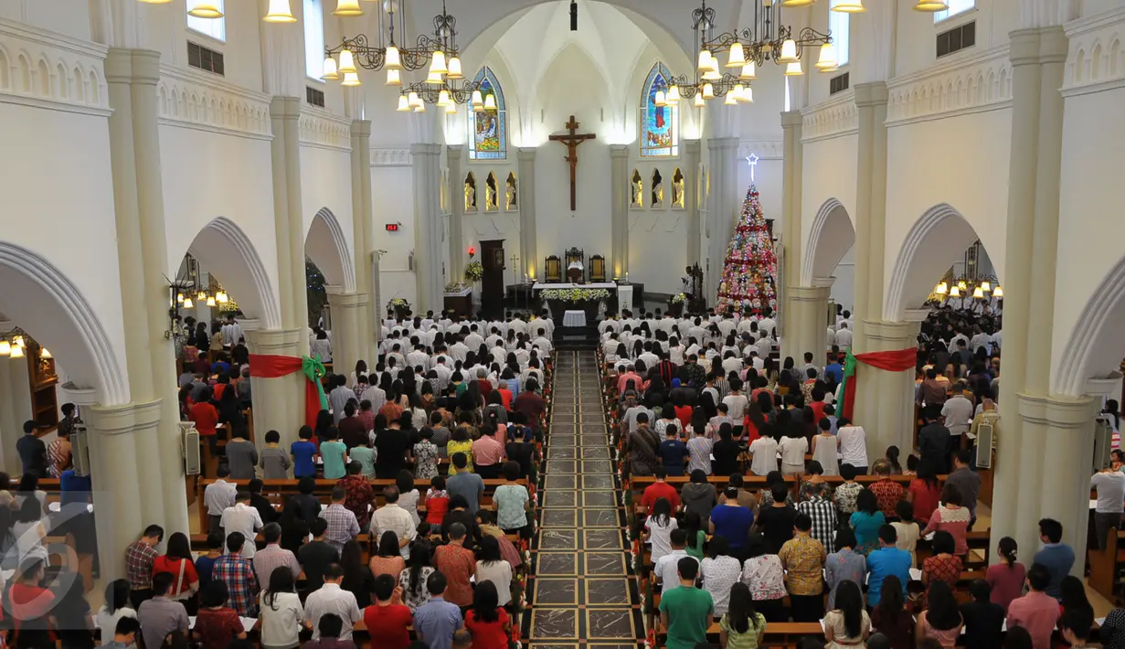 Para jemaat saat melakukan ibadah di Gereja Santo Laurensius, Alam Sutra, Tangerang, Kamis (24/12). Anggota kepolisian dan TNI berjaga disekitaran gereja untuk menanggulangi hal - hal yang tidak diinginkan. (Liputan6.com/Faisal R Syam)