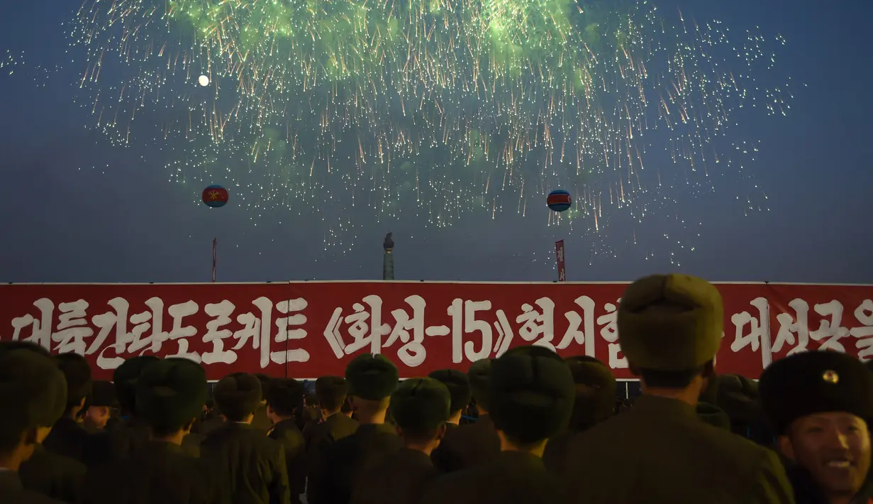 Tentara Korea Utara menyaksikan kembang api saat mengikuti demonstrasi untuk merayakan deklarasi Korea Utara di Pyongyang (29/11). Korut menyatakan menjadi negara nuklir usai uji coba peluncuran rudal antar benua atau balistik. (AFP Photo/Kim Won-Jin)