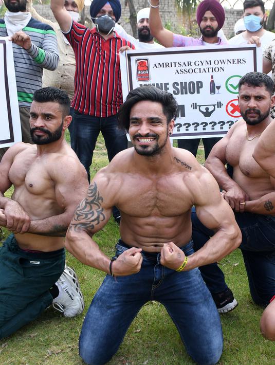 Pemilik dan pelatih gym memamerkan otot mereka saat protes menuntut pemerintah membuka kembali pusat kebugaran di Amritsar, India, Minggu (7/6/2020). Mereka meminta aktivitas tempat olahraga gym juga diizinkan buka setelah pelonggaran lockdown, bukan hanya kegiatan perekonomian. (NARINDER NANU/AFP)