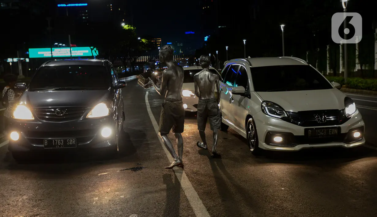 Manusia silver saat menghibur pengendara bermotor di perempatan kawasan Senayan, Jakarta, Sabtu (9/5/2020). Di tengah pandemi Covid-19 para manusia silver atau disebut "Patung Berjalan" itu tetap mengais rezeki untuk memenuhi kebutuhan sehari-hari (merdeka.com/Imam Buhori)