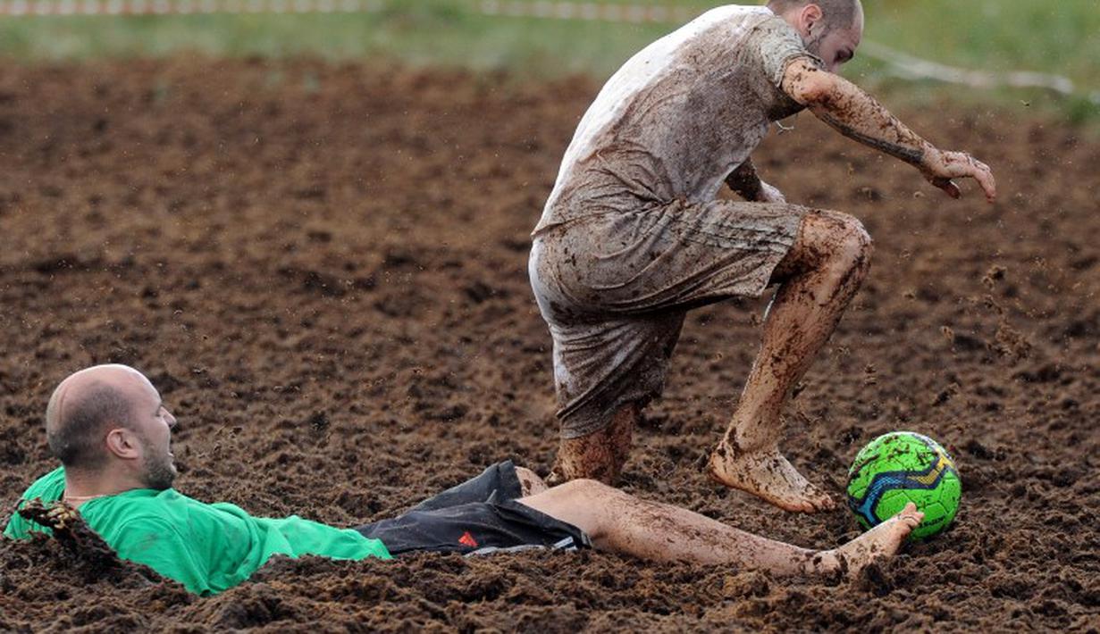 Pemain sepak bola rawa berebut bola dalam turnamen memperebutkan Piala Rusia yang berlangsung di Saint Petersburg, Rusia. Sabtu (27/6). (AFP PHOTO/OLGA MALTSEVA)