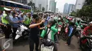 Petugas menenangkan pengadara Go-Jek yang terlibat kericuhan di Jakarta, Selasa (22/3). Ratusan Go-Jek mendatangi para sopir taksi karena tersebar isu pemukulan terhadap beberapa pengendara Go-Jek oleh sopir taksi.  (Liputan6.com/Immanuel Antonius)