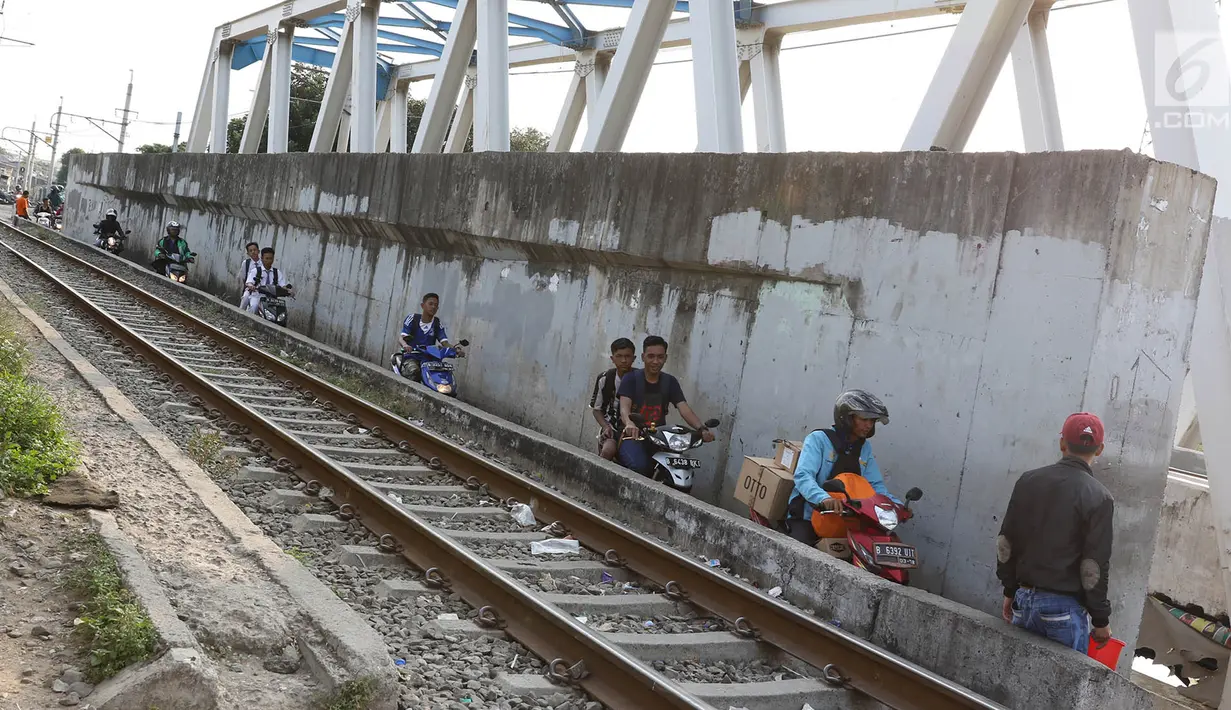 Suasana jalan setapak di pinggir rel kereta di kawasan Tambora, Jakarta, Senin (10/7). Tidak tersedianya akses jalan untuk putar balik membuat warga terpaksa memanfaatkan jalan setapak tersebut. (Liputan6.com/Immanuel Antonius)