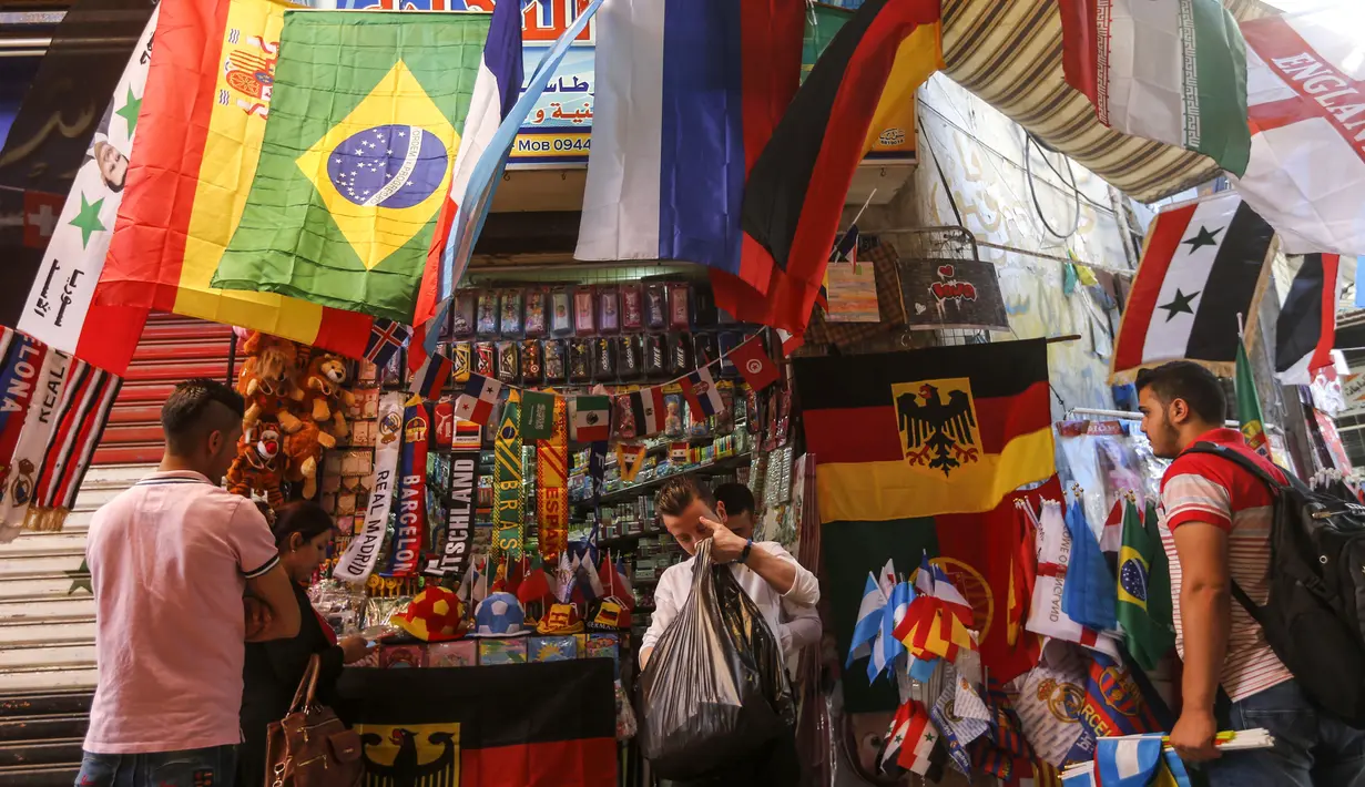 Sejumlah pembeli mencari pernak-pernik negara yang berpartisipasi pada Piala Dunia FIFA 2018 di jalan pasar di kota tua Damasku, Suriah (6/6). Piala Dunia akan digelar pada 14 Juni 2018 di Rusia. (AFP Photo/Louai Beshara)