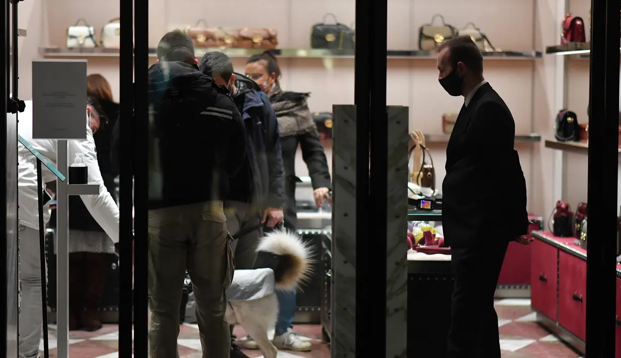 Orang-orang berbelanja menjelang perayaan Natal di Milan, Italia, pada 7 Desember 2020. Italia mencatat 13.720 infeksi baru Covid-19 pada Senin (7/12) dan merupakan penambahan harian terendah sejak 20 Oktober lalu, yang mencapai 10.874 infeksi baru. (Xinhua/Daniele Mascolo)