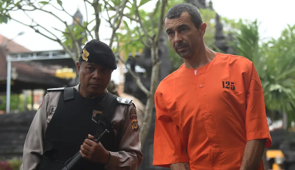 Warga negara Prancis Samuel Pierre Danguny dikawal oleh polisi sebelum konferensi pers di kantor polisi di Denpasar, Bali (18/3). Danguny ditangkap pada 15 Maret dengan kepemilikan 33 gram ganja dan 2 paket Hasis 16 gram. (AFP Photo/Sonny Tumbelaka)