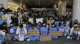 Perawat dan staf medis saat unjuk rasa rasa di sebuah rumah sakit di Hong Kong (13/8/2019). Para pemrotes berunjuk rasa menentang kebrutalan polisi pada aksi-aksi demonstrasi akhir pekan. (AP Photo/Kin Cheung)