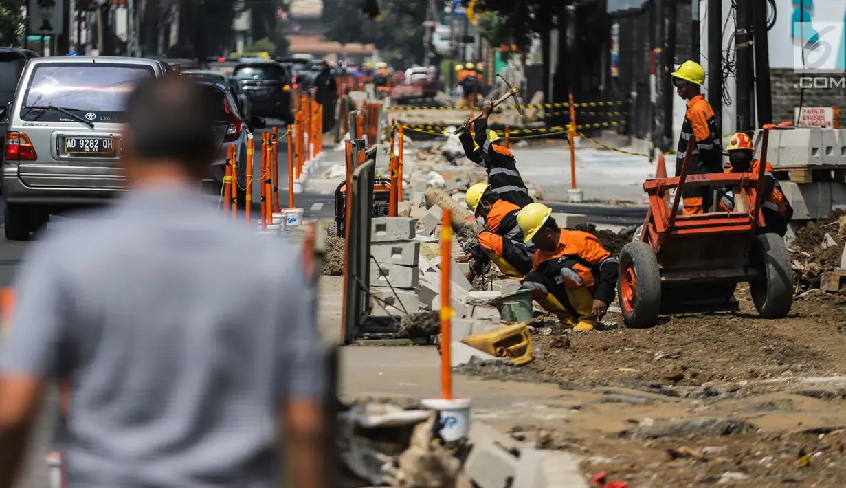 Pekerja menyelesaikan proyek revitaslisasi trotoar di kawasan Cikini, Jakarta, Senin (1/7/2019). Revitalisasi trotoar di kawasan Cikini hingga Kramat ditargetkan rampung pada Desember 2019. (Liputan6.com/Faizal Fanani)