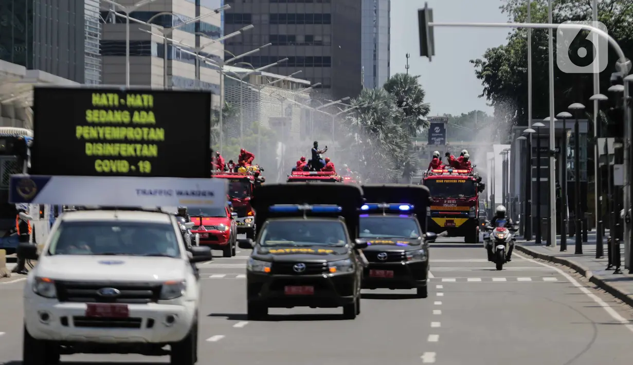 Petugas Dinas Pemadam Kebakaran Pemprov DKI melakukan penyemprotan cairan disinfektan di Jalan Thamrin, Jakarta, Selasa (31/3/2020). Penyemprotan yang dilakukan terus menerus itu untuk meminimalisir penyebaran COVID-19 di ruang udara dan ruas jalan. (Liputan6.com/Faizal Fanani)