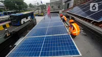 Teknisi Green Energy Nusantara Mandiri memasang PLTS Hybrid 6210 Wp battery 4,8 kwhpada atap rumah kantor di kawasan Manggarai Jakarta, Jumat (29/12/2023). (merdeka.com/Arie Basuki)