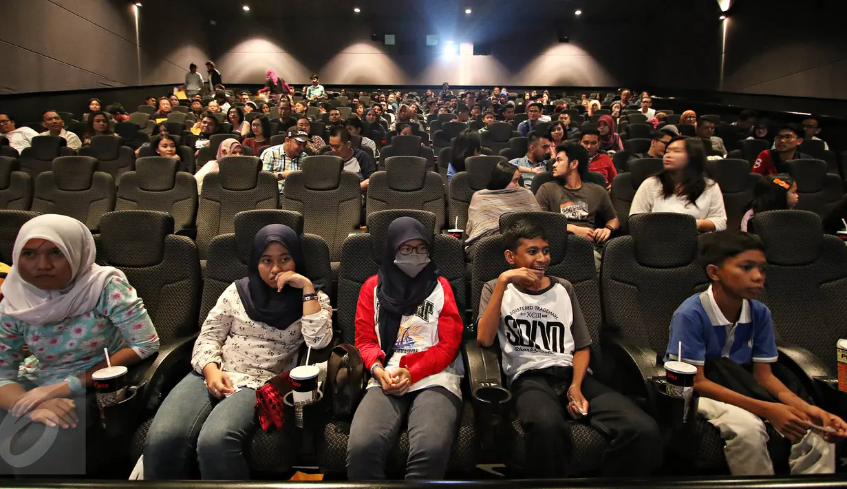 Pengunjung mengikuti kegiatan nonton bareng film di Blitz Grand Indonesia, Jakarta, Sabtu (7/11/2015). Cinemaholic Secret Agent bersama Lipton menyajikan kegiatan menarik, seperti doorprize dan photobooth. (Liputan6.com/Immanuel Antonius)