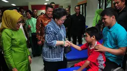Megawati Soekarnoputri menyalami seorang anak saat menghadiri  acara 60 tahun Yayasan Pembinaan Anak Cacat (YPAC) Jakarta, Rabu (5/11/2014) (Liputan6.com/Johan Tallo)