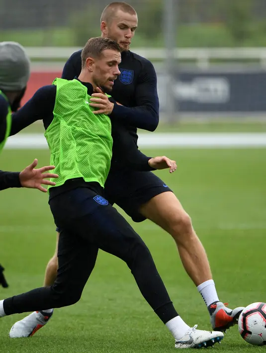 Gelandang Inggris, Jordan Henderson berebut bola dengan Eric Dier saat latihan di St George's Park di Burton-on-Trent, Inggris tengah (4/9). Inggris akan bertanding melawan Spanyol laga persahabatan internasional 8 September. (AFP Photo/Paul Ellis)