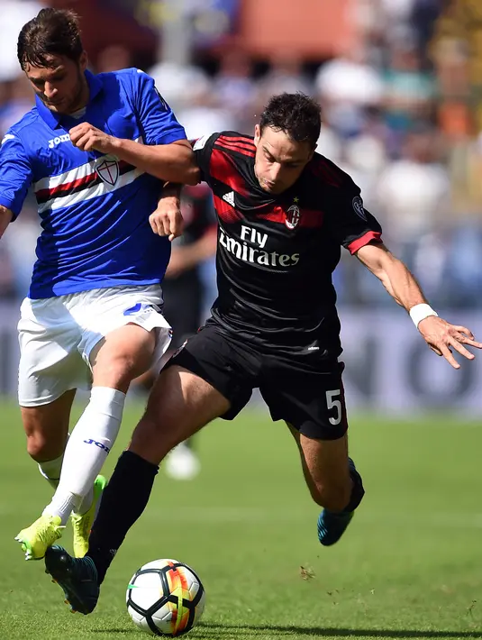 Bek Sampdoria, Bartosz Bereszynski berusaha merebut bola gelandang AC Milan, Giacomo Bonaventura saat bertanding pada Liga Serie A Italia di Stadion Luigi Ferraris di Genoa (24/9). AC Milan takluk 2-0 dari Sampdoria. (AFP Photo/Filippo Monteforte)
