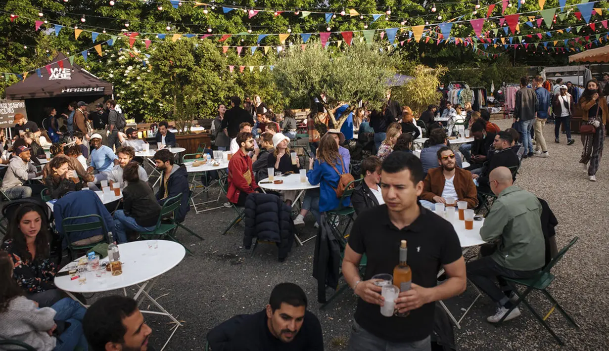 Orang-orang bersosialisasi dan minum di teras kafe di Paris, Prancis, Sabtu (5/6/2021). Jumlah kasus baru COVID-19 di Prancis semakin menurun. (AP Photo/Lewis Joly)
