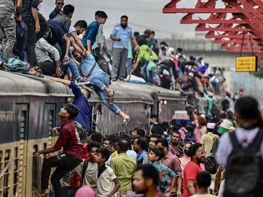 Orang-orang menaiki kereta api di stasiun kereta Tongi saat mereka dalam perjalanan pulang menjelang Idul Adha, di Tongi di pinggiran Dhaka, Bangladesh, Jumat (14/6/2024). (MUNIR UZ ZAMAN / AFP)